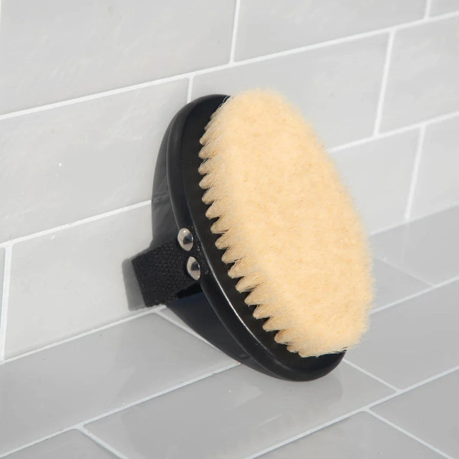 Kitsch Exfoliating Body Dr Brush against a tiled bathroom wall.