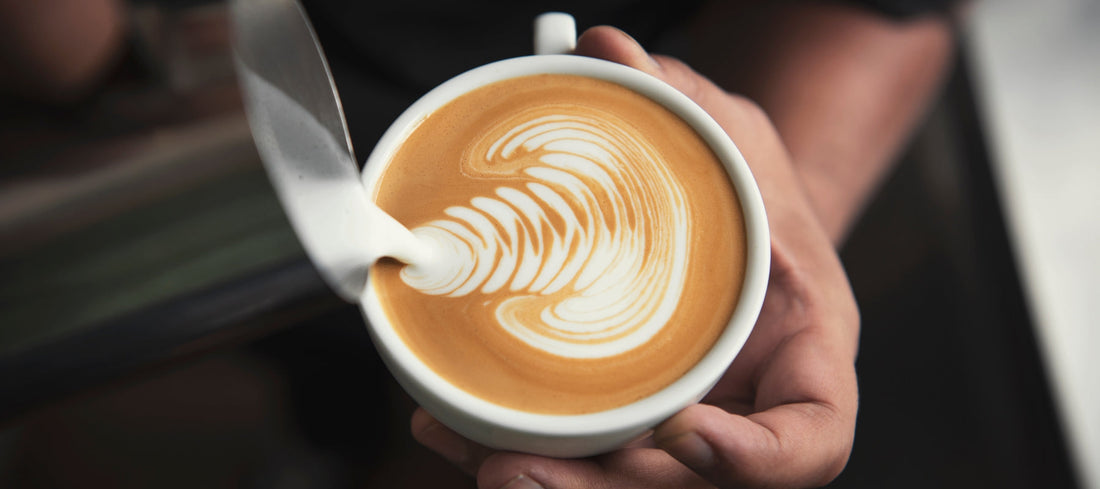 Barista making a coffee to illustrate caffeine intake and how coffee affects stress, sleep and digestion.