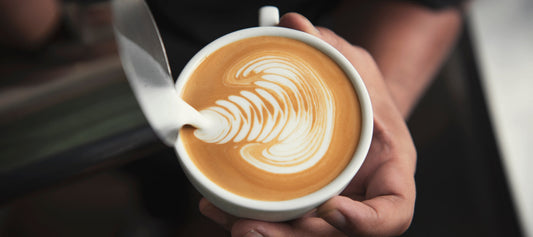 Barista making a coffee to illustrate caffeine intake and how coffee affects stress, sleep and digestion.