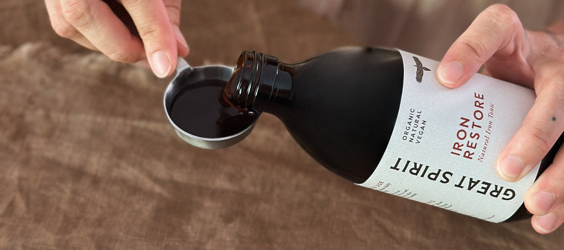 Great Spirit Iron Restore liquid iron supplement poured into a measuring spoon to support iron absorption and low iron levels.