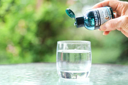 Elektra Magnesium Water Drops being dispensed into water to support hydration and magnesium absorption.