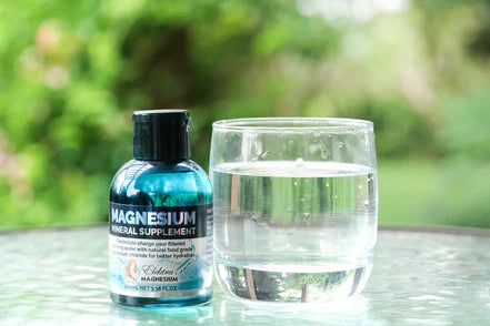 Elektra Magnesium Water Drops beside a glass of water for hydration, mineral balance and magnesium intake.