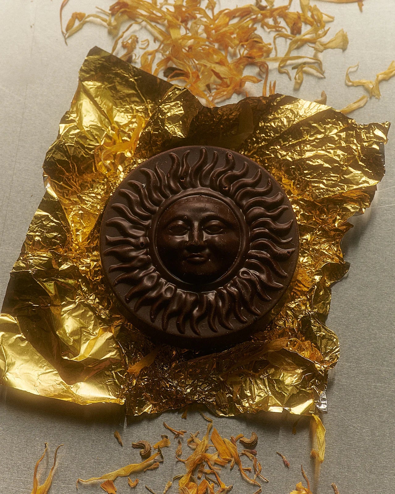 Loco Love Chuncho Drinking Cacao Sun Disc – pure wildcrafted cacao disc resting on gold foil wrapper, showcasing the texture and purity of ceremonial grade cacao.
