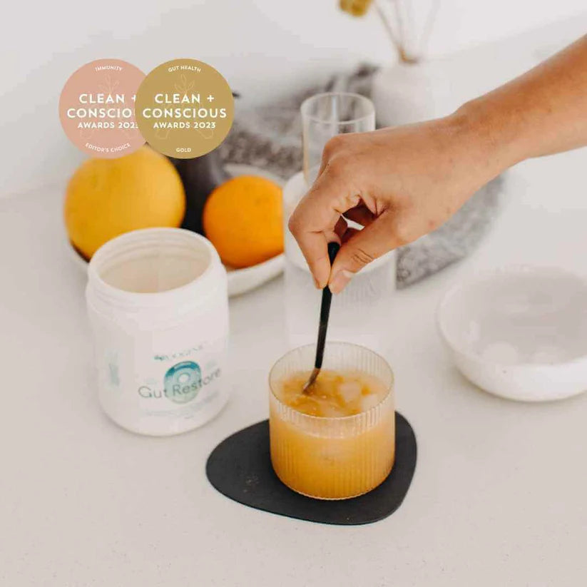 Roogenic Gut Restore Superfood being stirred into water, award-winning gut health and digestive support formula.