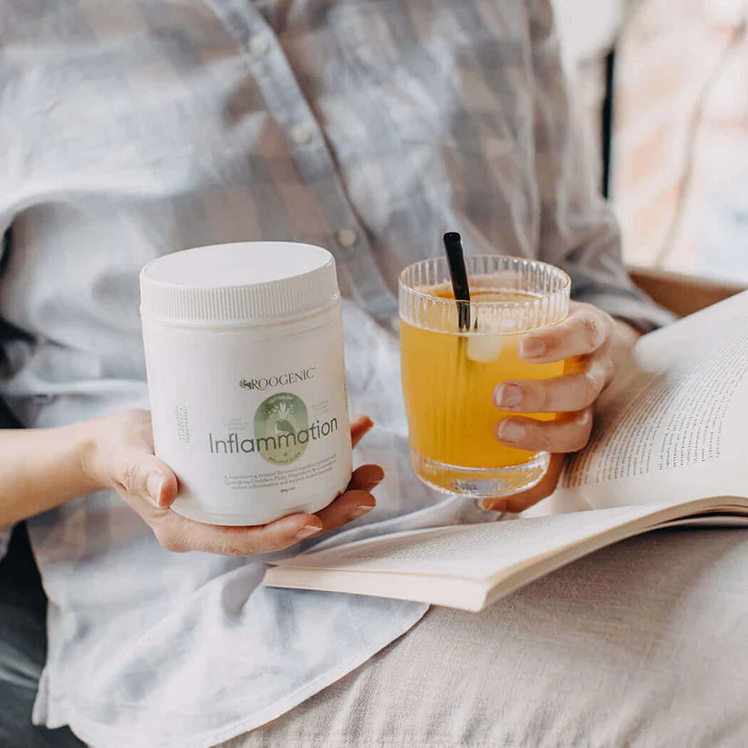 Roogenic Inflammation Superfood mixed in water, held with product tub to support inflammation reduction and muscular system health.