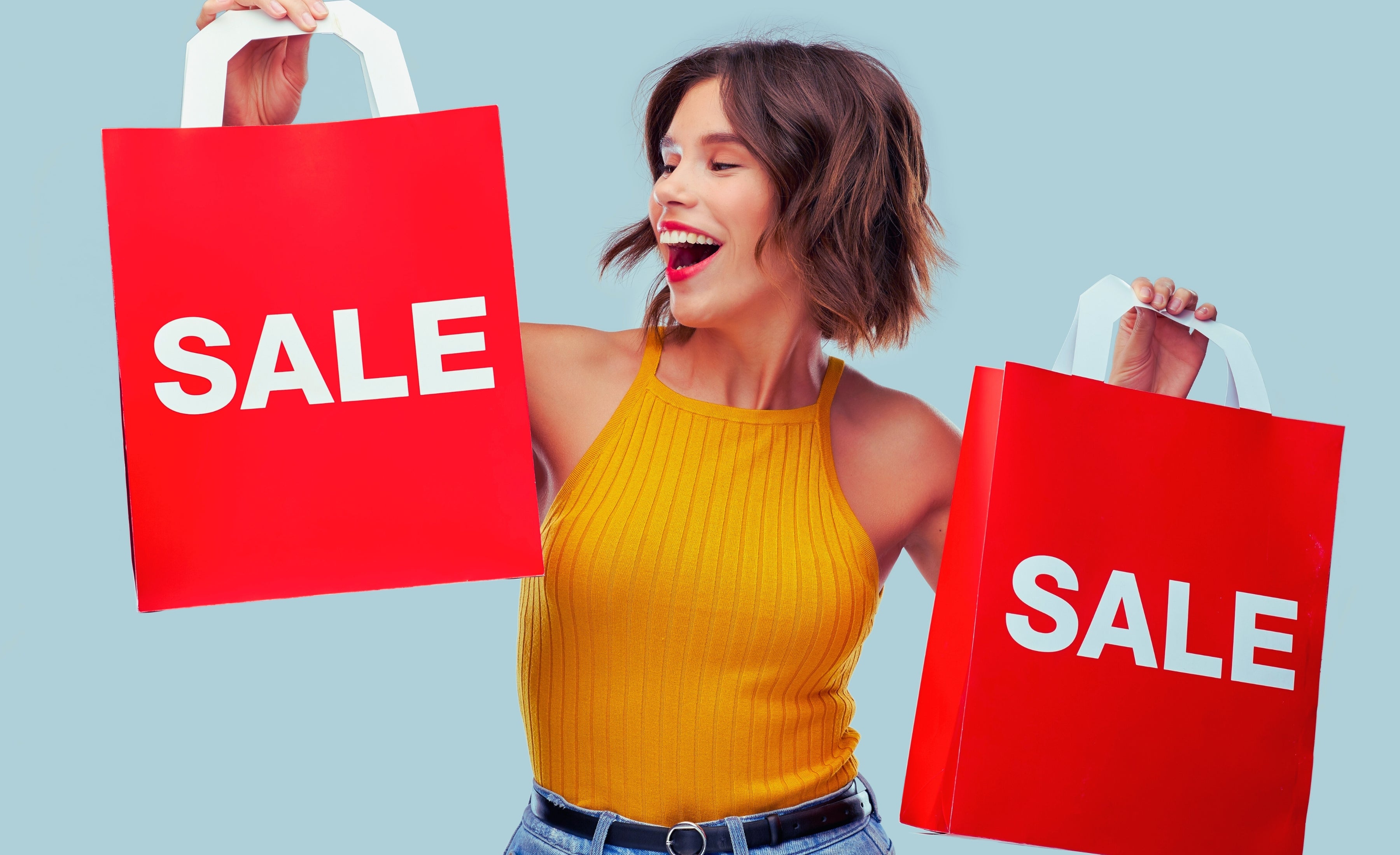 Woman holding “SALE” shopping bags promoting current specials at Renew Health Co.