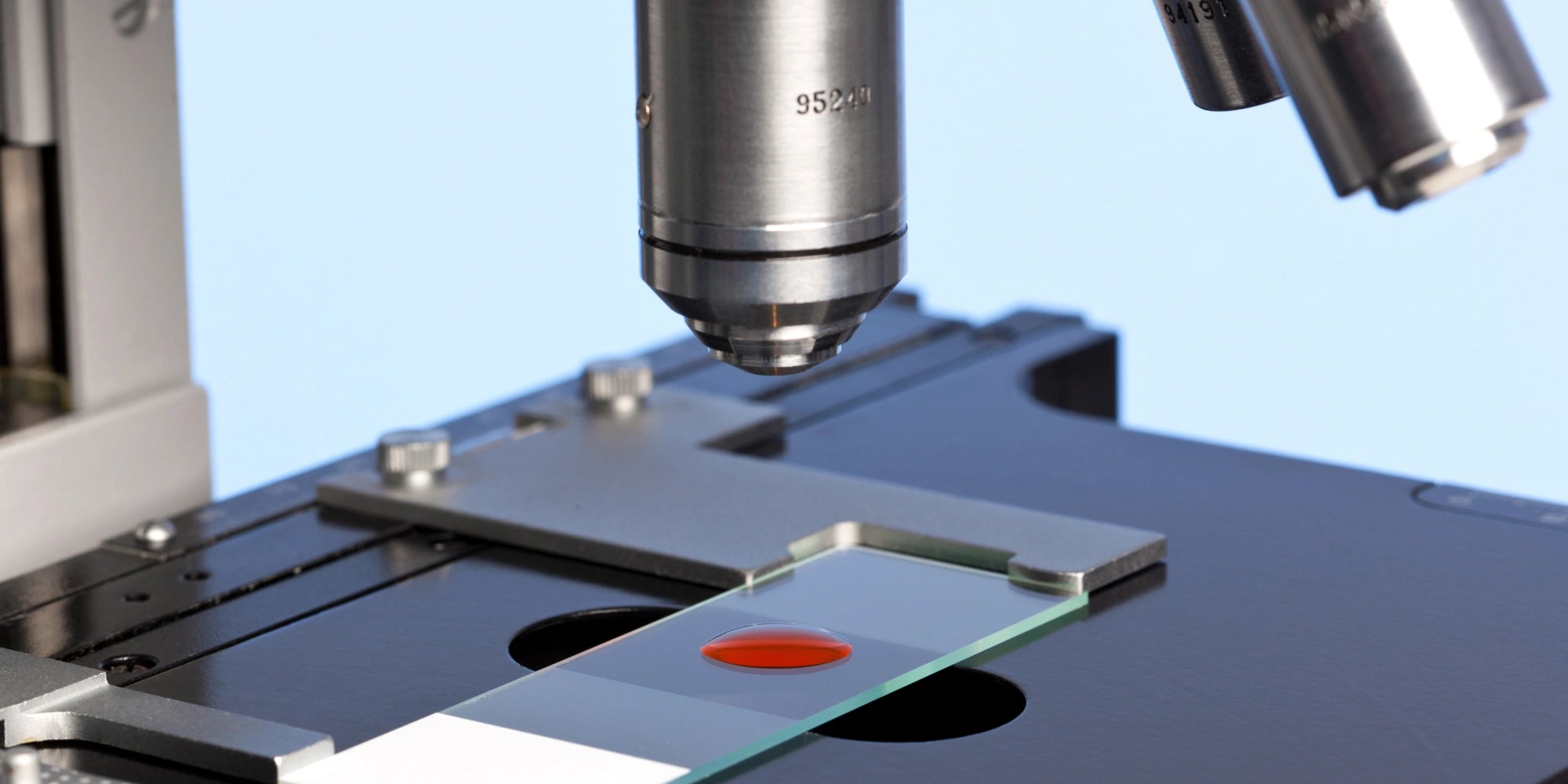 Microscope with a drop of blood on a glass slide.