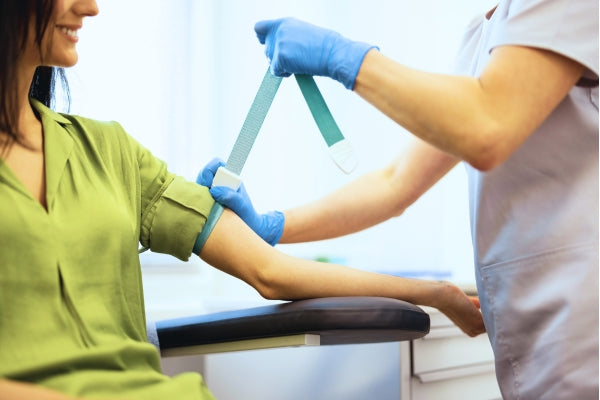 Person receiving a blood test with a nurse wearing gloves